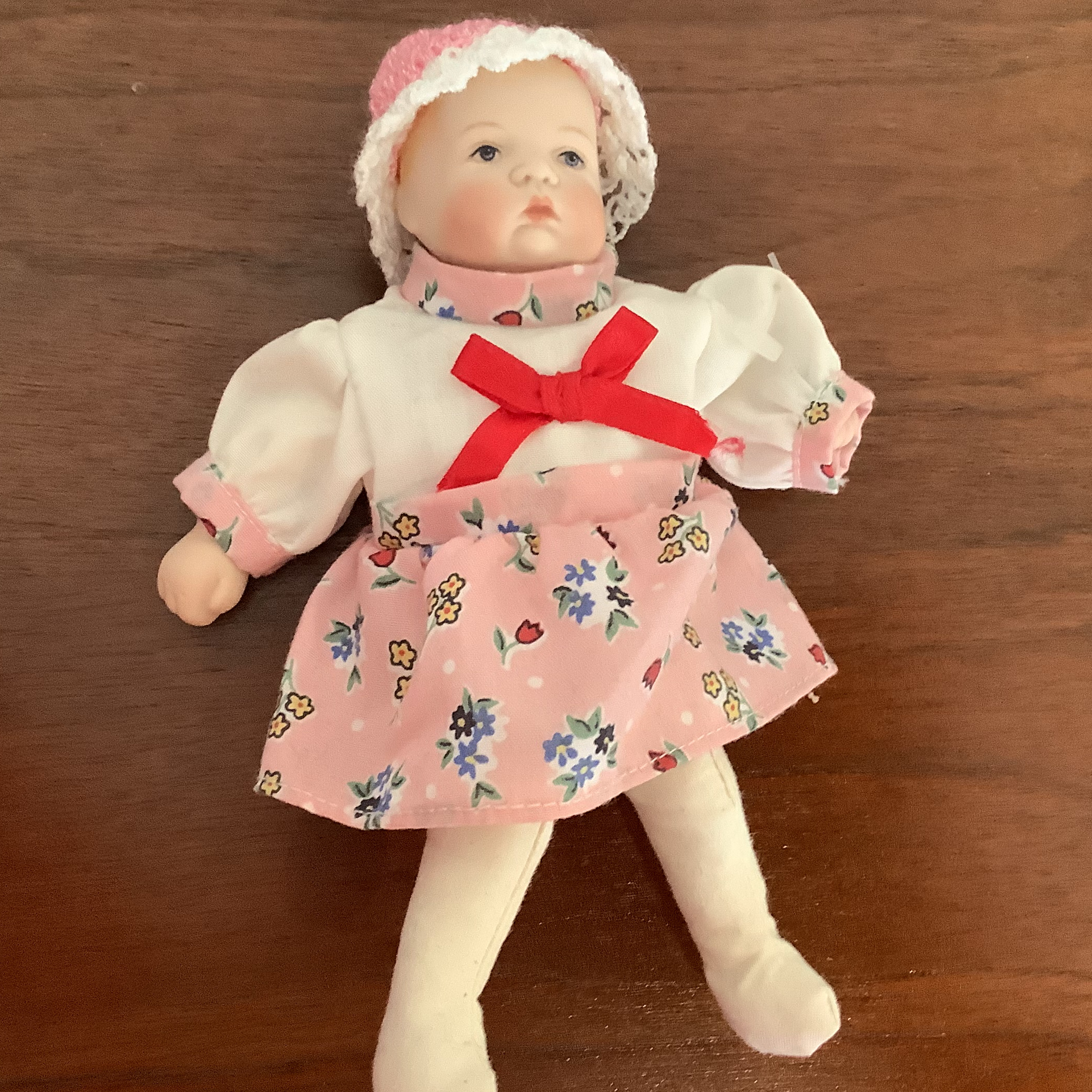 7-inch modern doll Sarah in white and pink dress, lying on a table