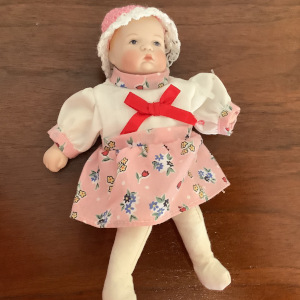 7-inch modern doll Sarah in white and pink dress, lying on a table