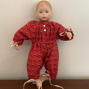 8-inch modern baby doll with painted hair and blue eyes, in a red onesie
