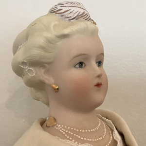 Parien lady doll with painted jewels in hair and around neck