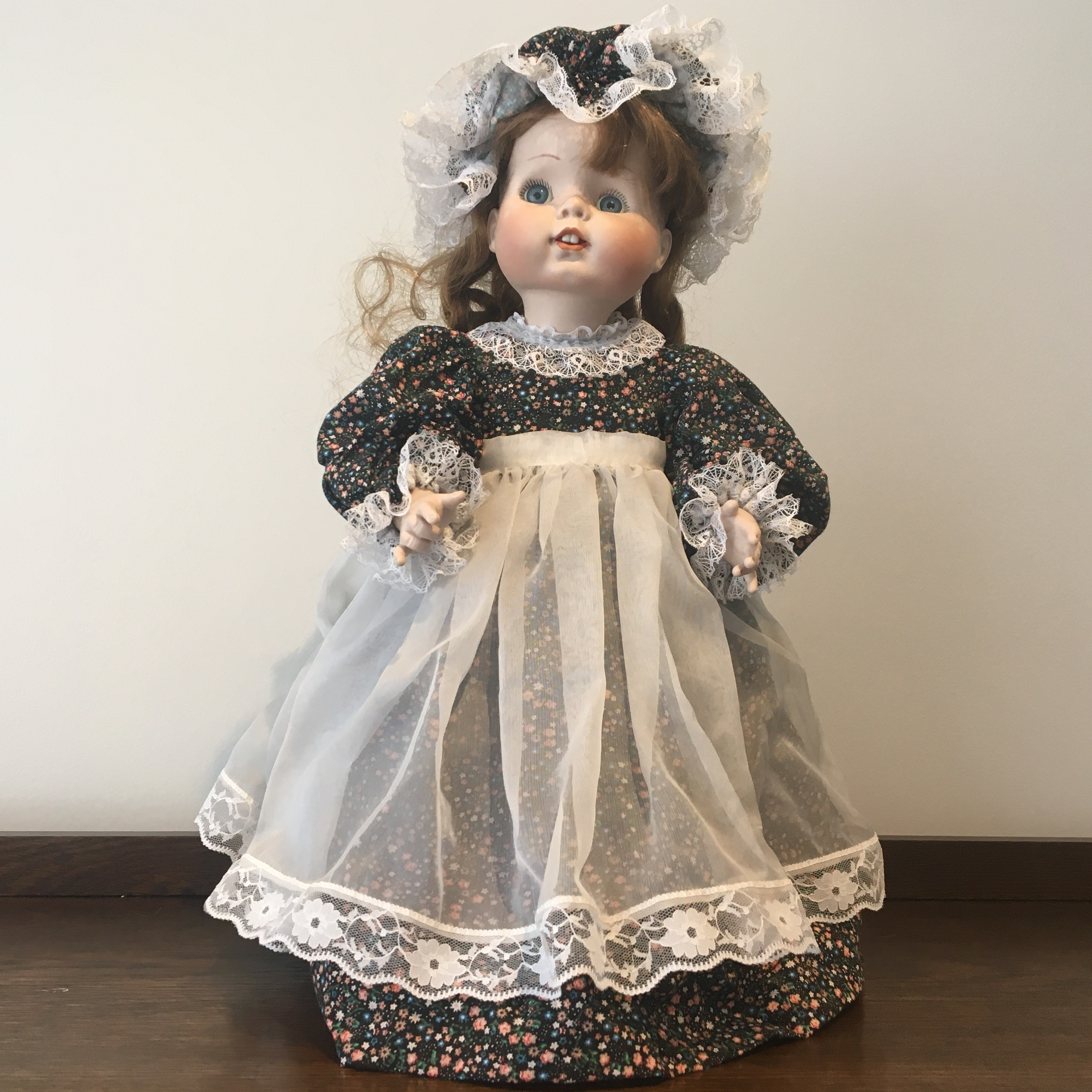19-inch modern doll with brown hair, calico dress and bonnet, and white apron