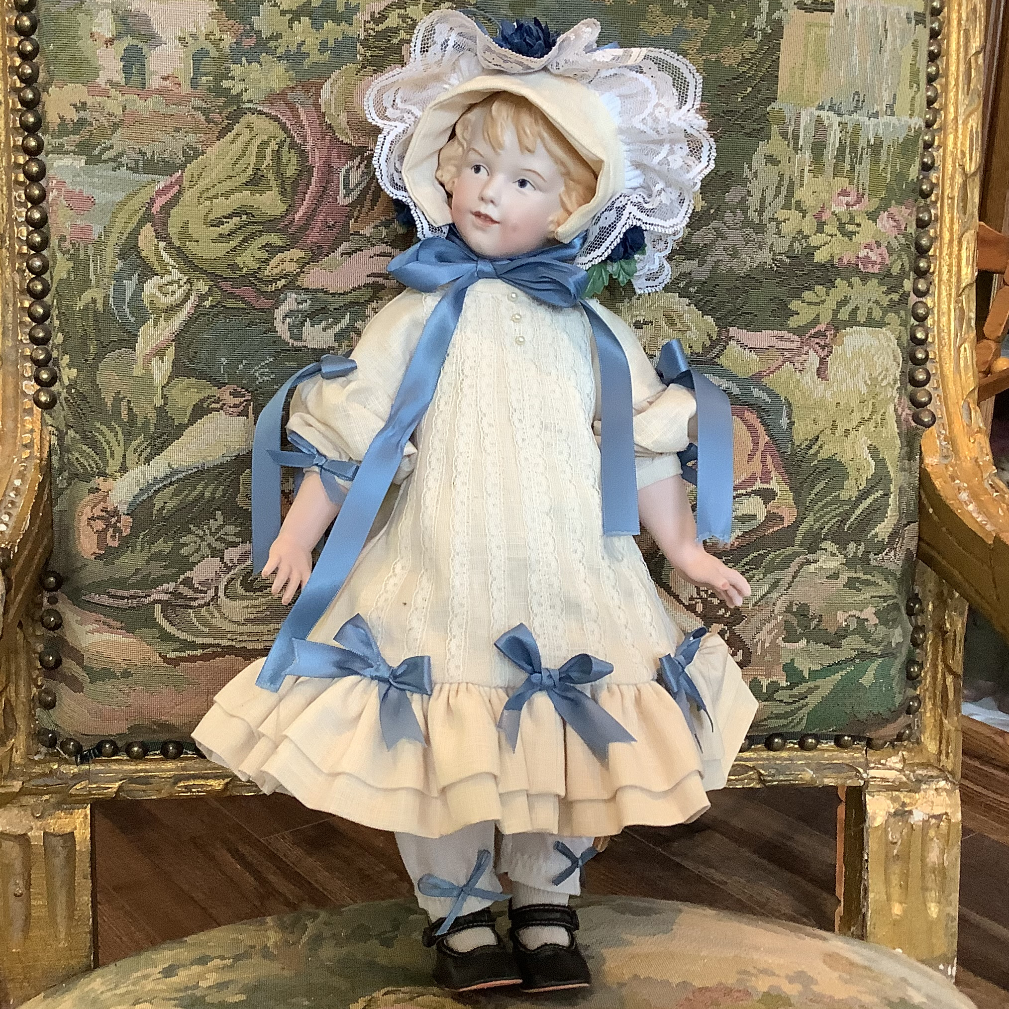 Reproduction Heubach character doll in white dress with blue ribbon
