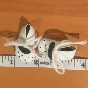 White shoes with decorative holes on the toes and string laces