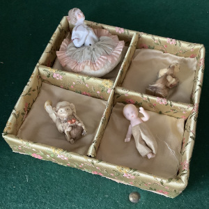 Four-part silk-lined display box containing four figurines