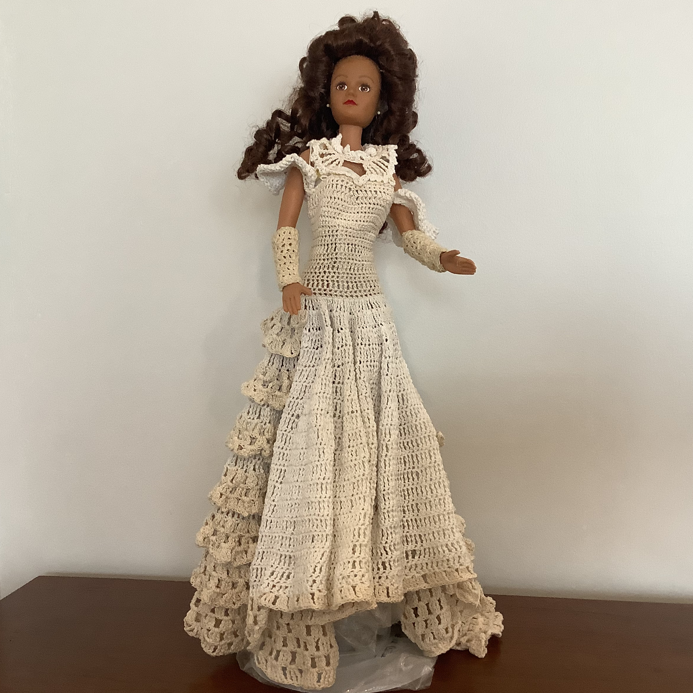 Tall, brown-skinned modern fashion doll in off-white crocheted dress
