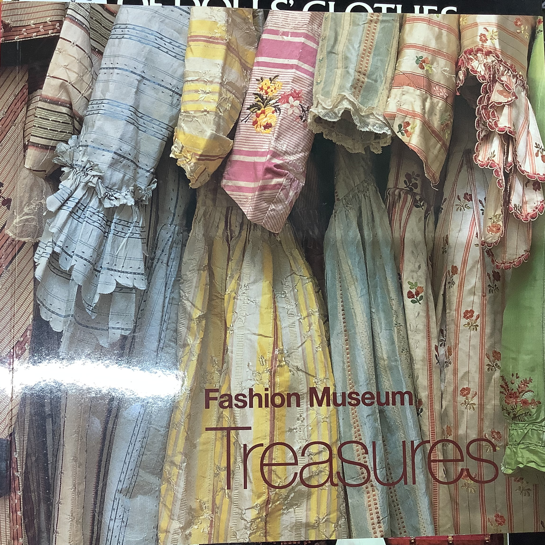 Book depicting a row of antique silk dresses viewed from the side