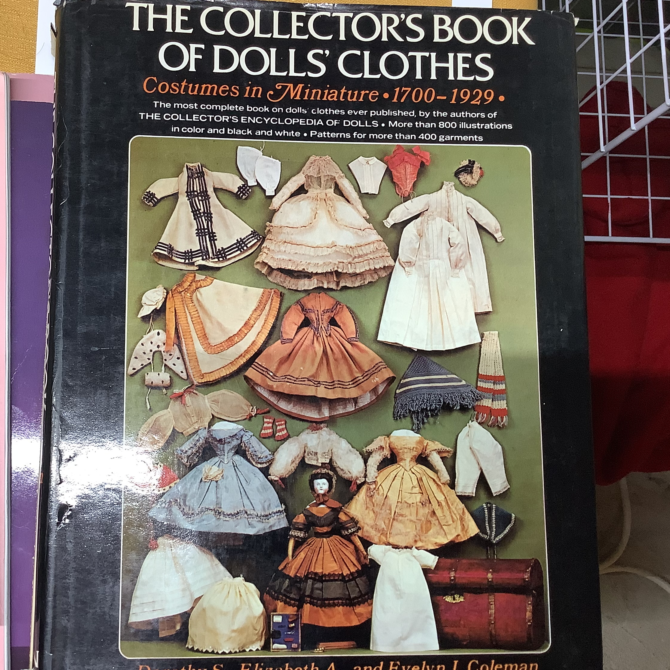 Hardcover book depicting antique doll dresses in upperclass styles