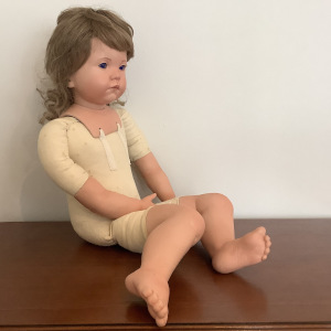 Nude light-skinned toddler doll with bent knees, glass eyes and ash-blond hair