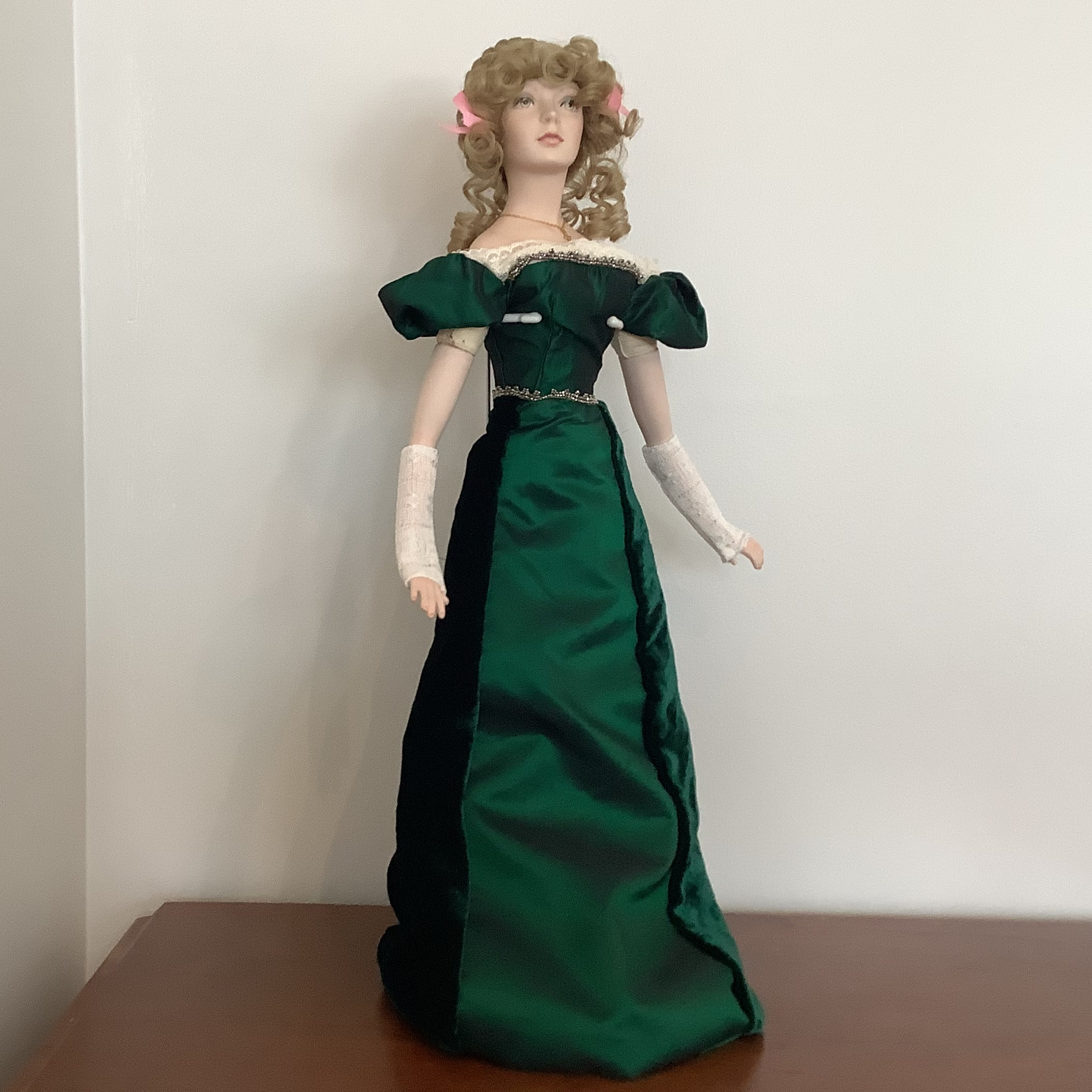 Tall, slim, light-skinned, green-eyed modern lady doll in green dress with curly blond hair and painted green eyes