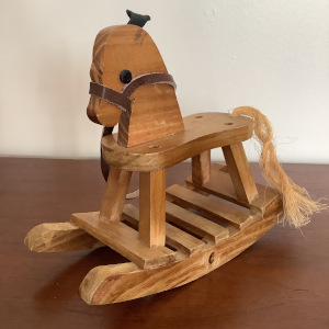 Small wooden rocking horse with leather halter and rope tail
