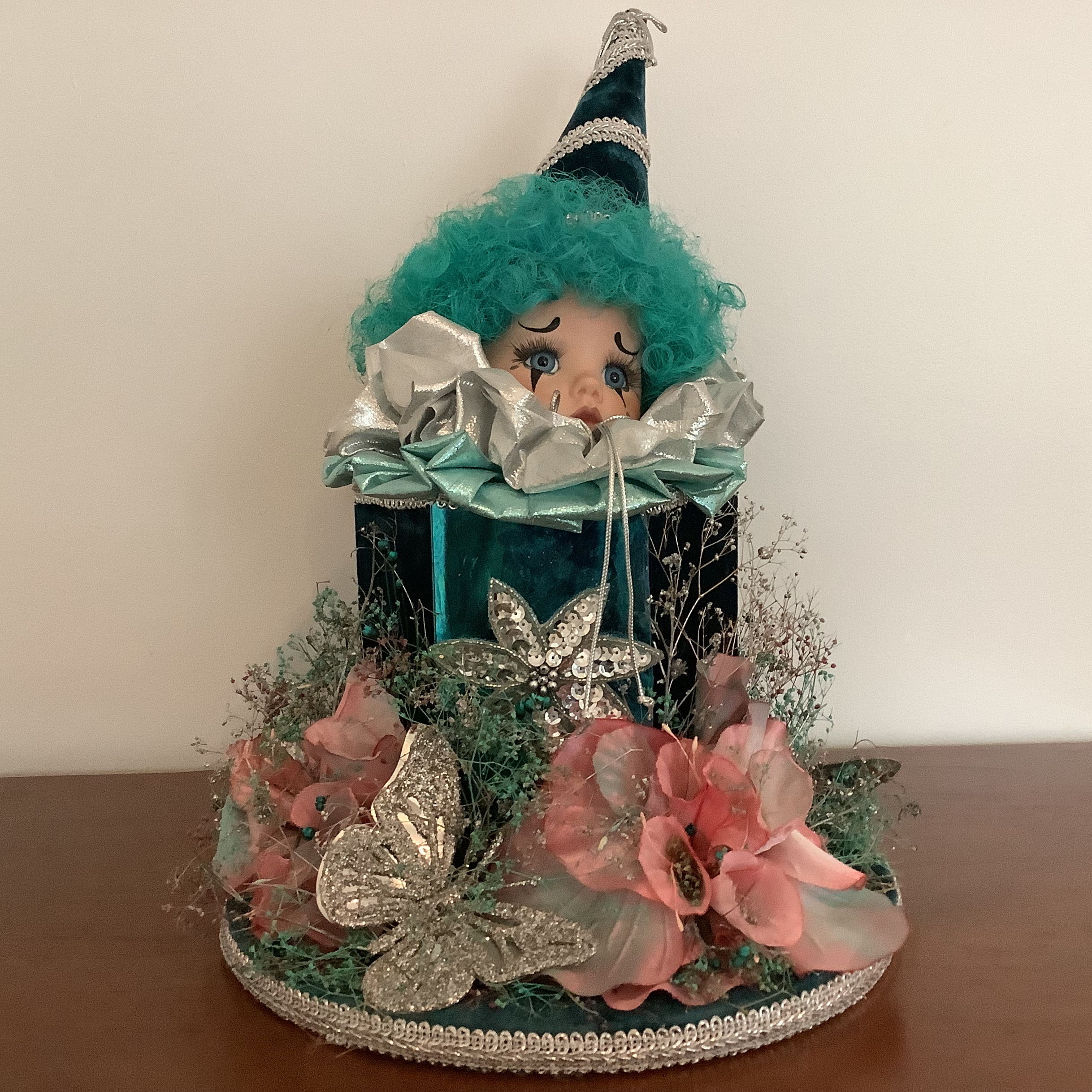Party-themed music box with clown doll head peeking out open top. Green.