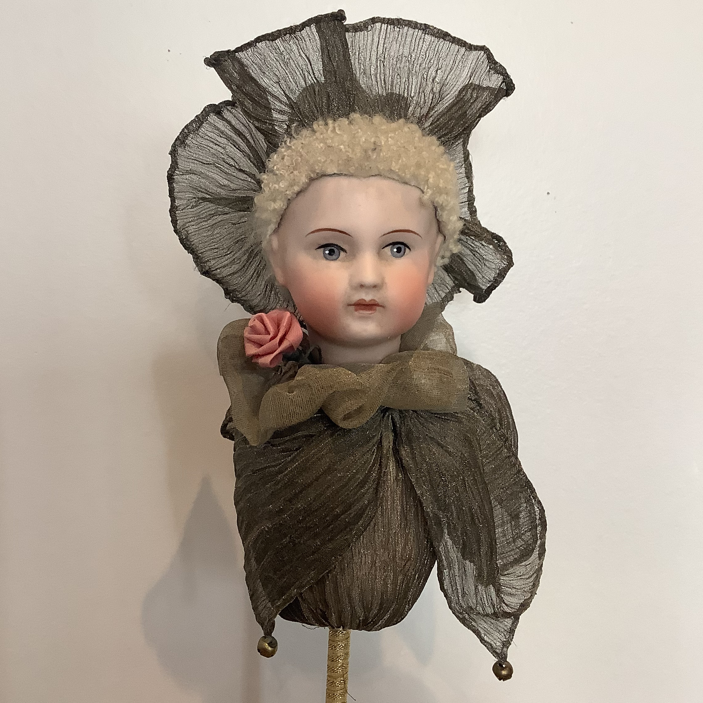 Partial doll on stick with sparkly grey costume and bells.