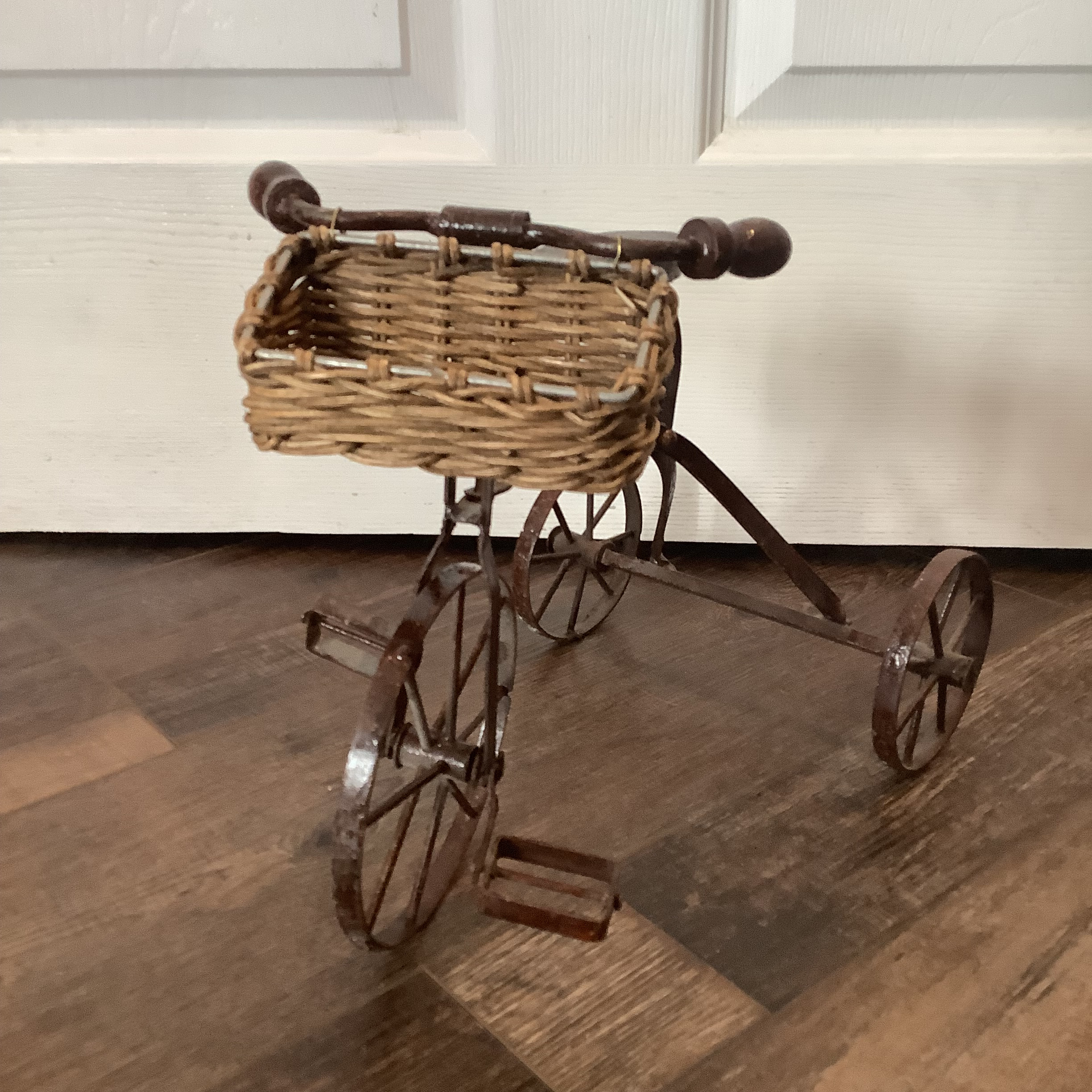 Small black tricycle with unpainted wicker basket