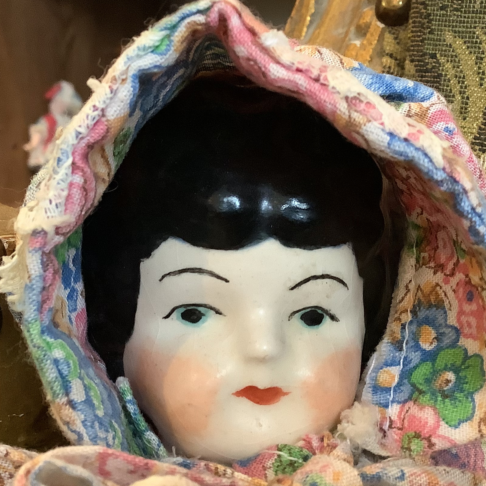 Face of china doll with painted black hair and light blue eyes