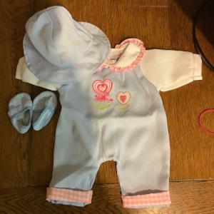 Blue romper with white sleeves and pink embroidery and trim, with matching blue hat and soft shoes
