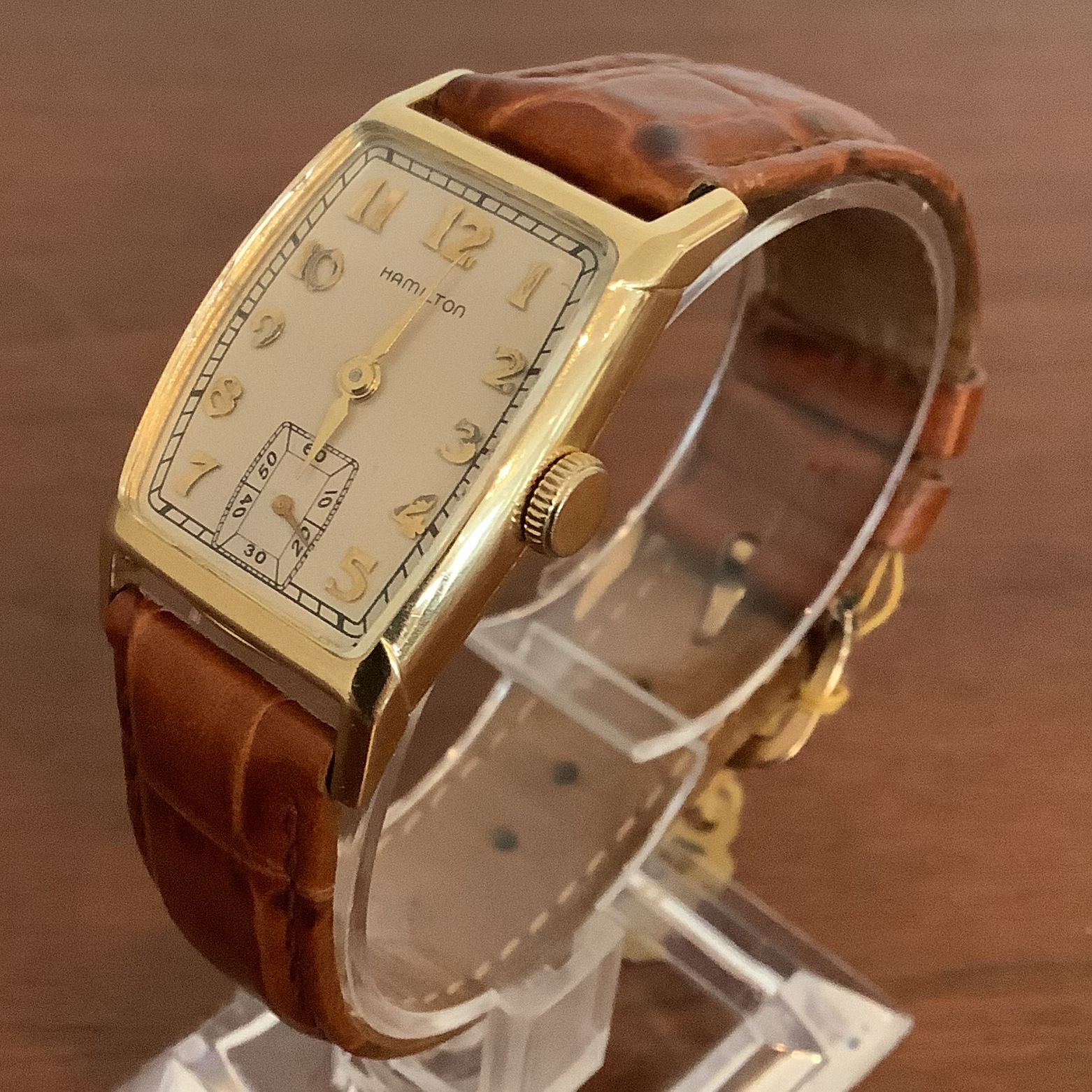 Hamilton cushion case wristwatch in 14 karat gold measuring 35 by 21 millimetres, with brown leather band