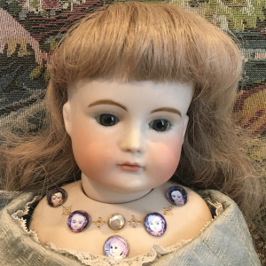 XI Girl with inset cabochons around collarbone, depicting other dolls