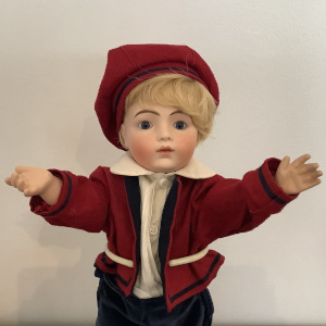Small 15-inch reproduction Bru boy doll in red and blue suit, front view