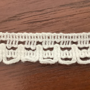 Slightly fuzzy white synthetic yarn lace