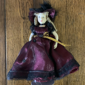 Very small 8-inch modern lady doll in purple dress and hat in synthetic fibres