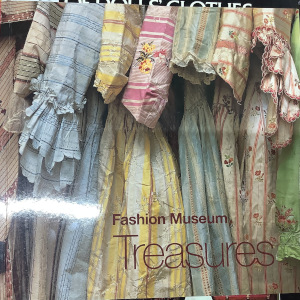 Book depicting a row of antique silk dresses viewed from the side