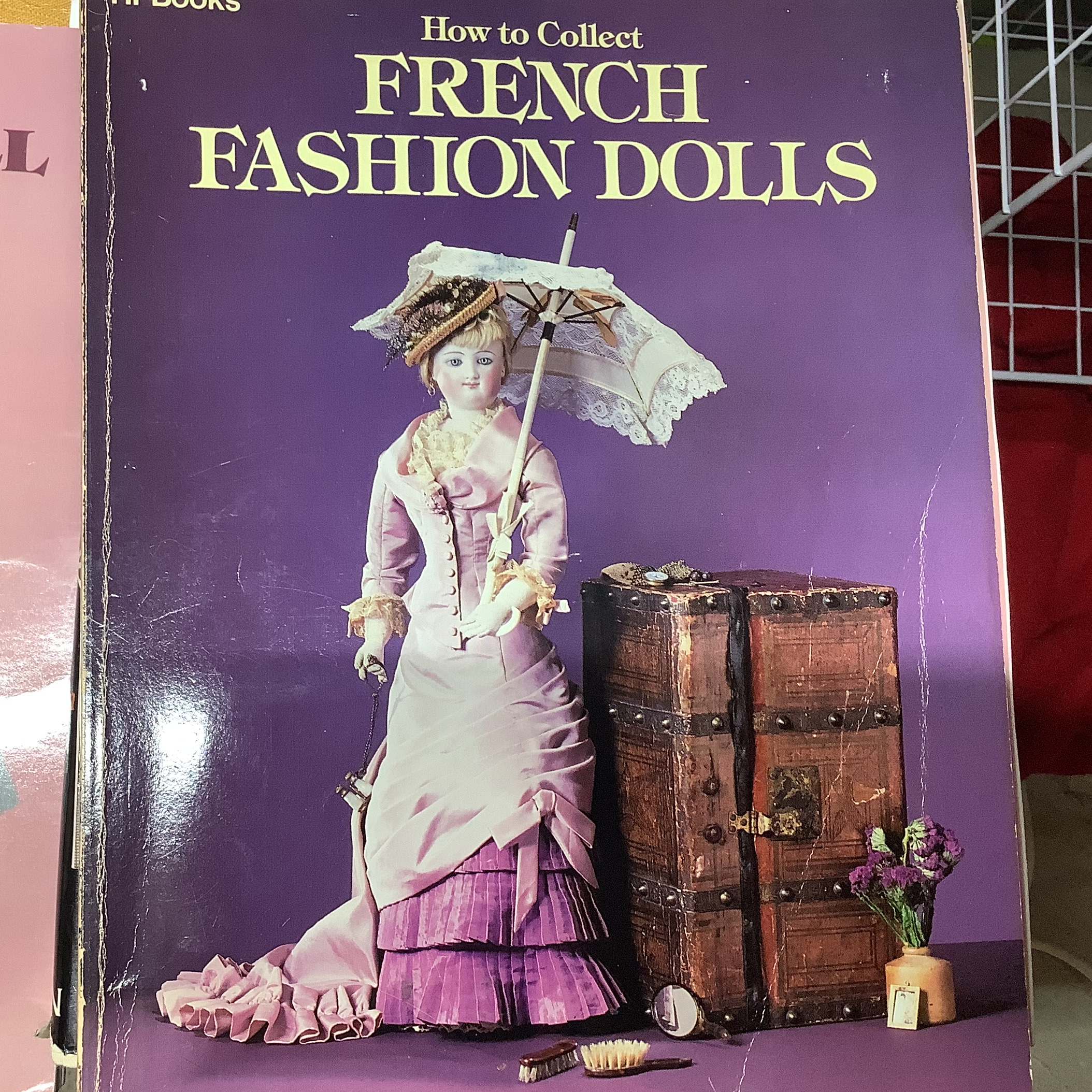 Hardcover book depicting a lady doll holding a parasol