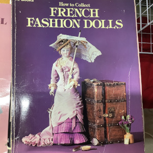 Hardcover book depicting a lady doll holding a parasol