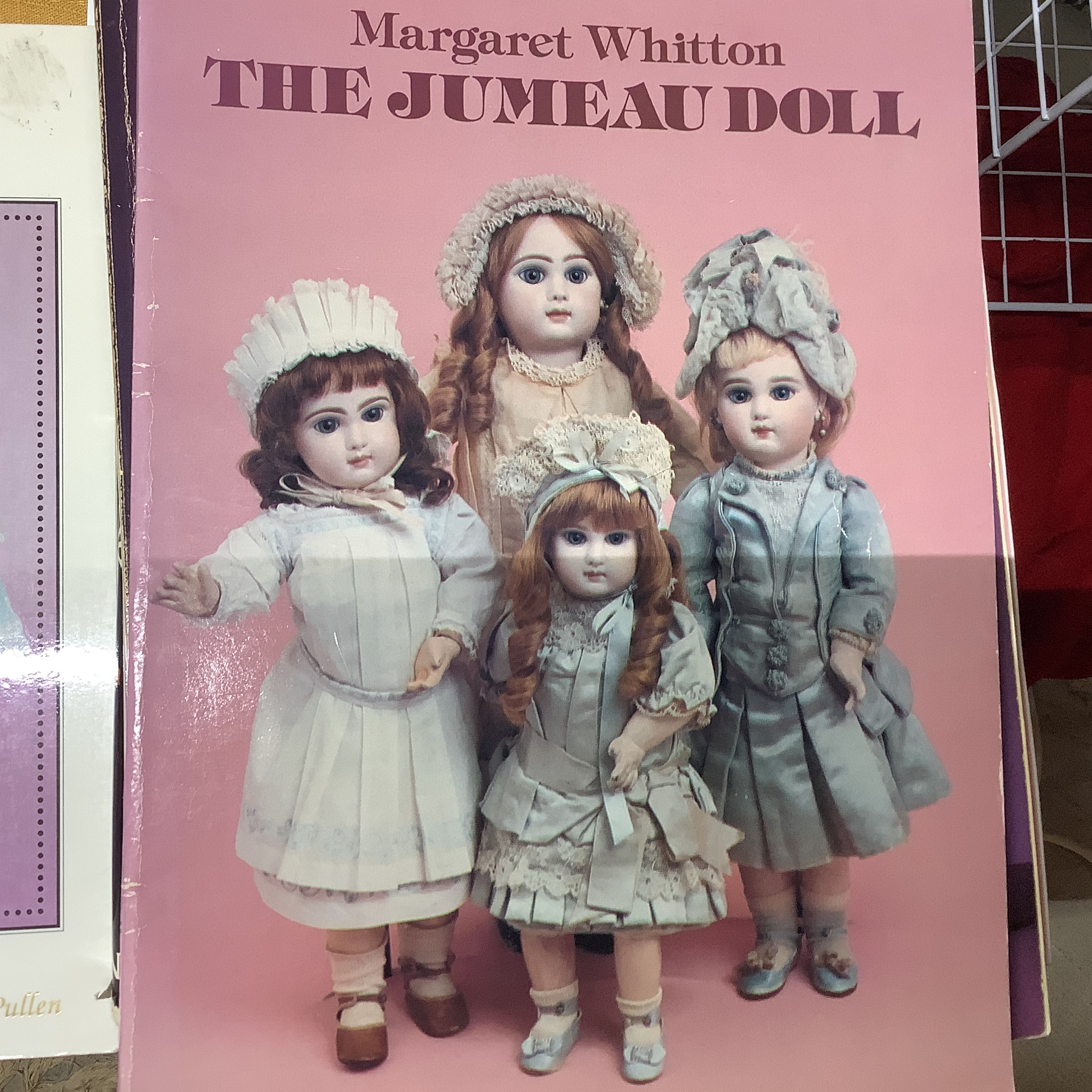 Hardcover book depicting four child dolls in upperclass dress