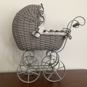 Grey-painted wicker stroller with extensive padded lining and curtains in a floral print