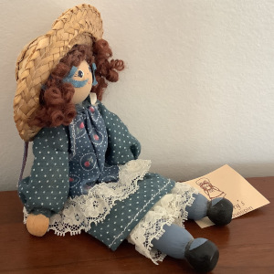 Clothespin doll in blue dress with painted face and straw hat