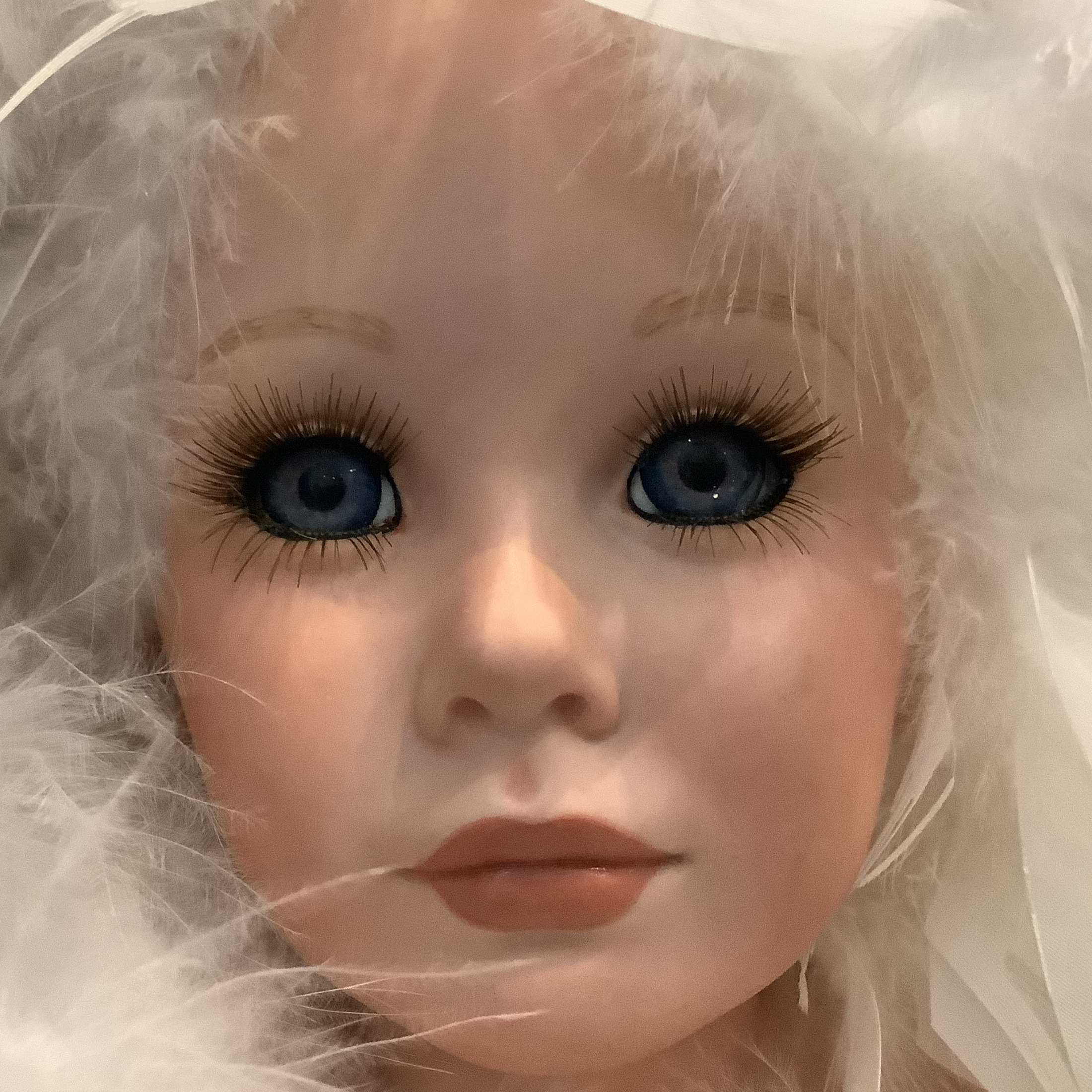 Dancer doll face; light-skinned female doll with dark blue eyes and brown lipstick