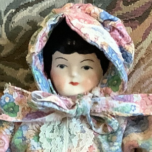 White china doll in pink and blue calico dress