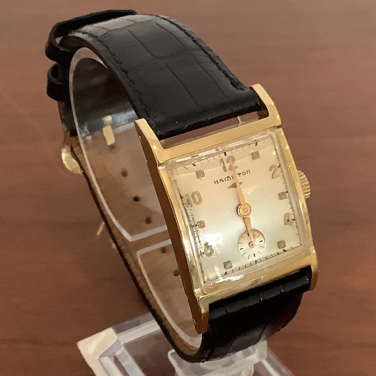 Hamilton rectangular case watch in 14 karat gold, 35 by 22 millimetres, with high-domed cylindrical crystal with black leather band